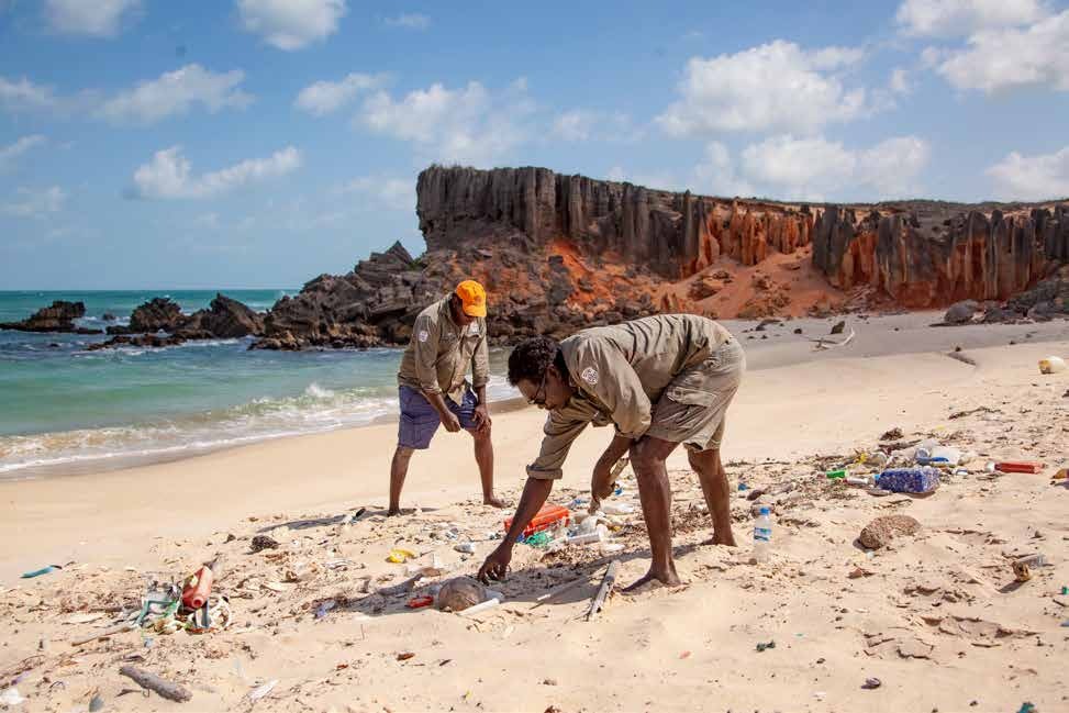 Rangers cleaning rubbish on a beach.