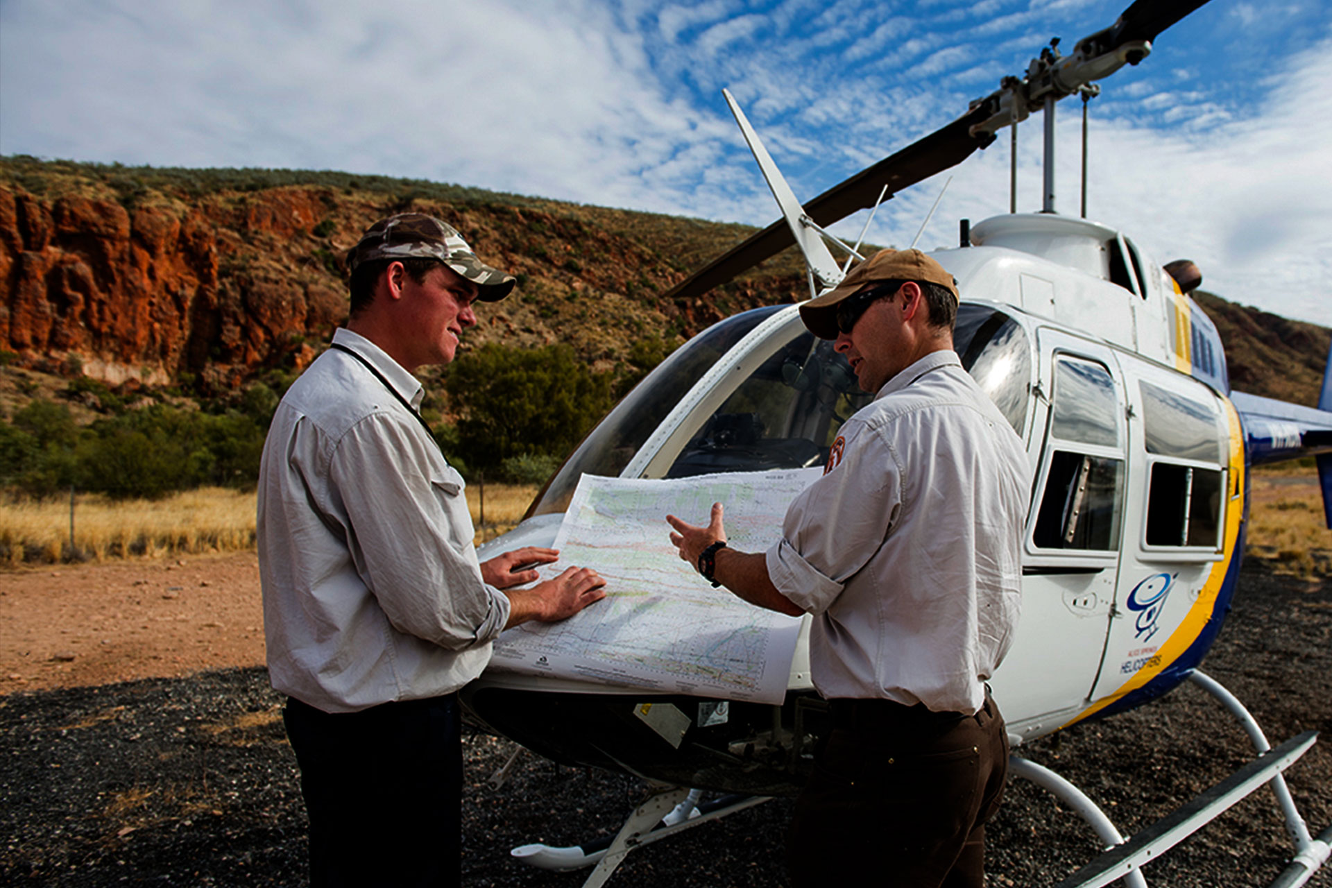 Rangers with a map in front of a helicopter.