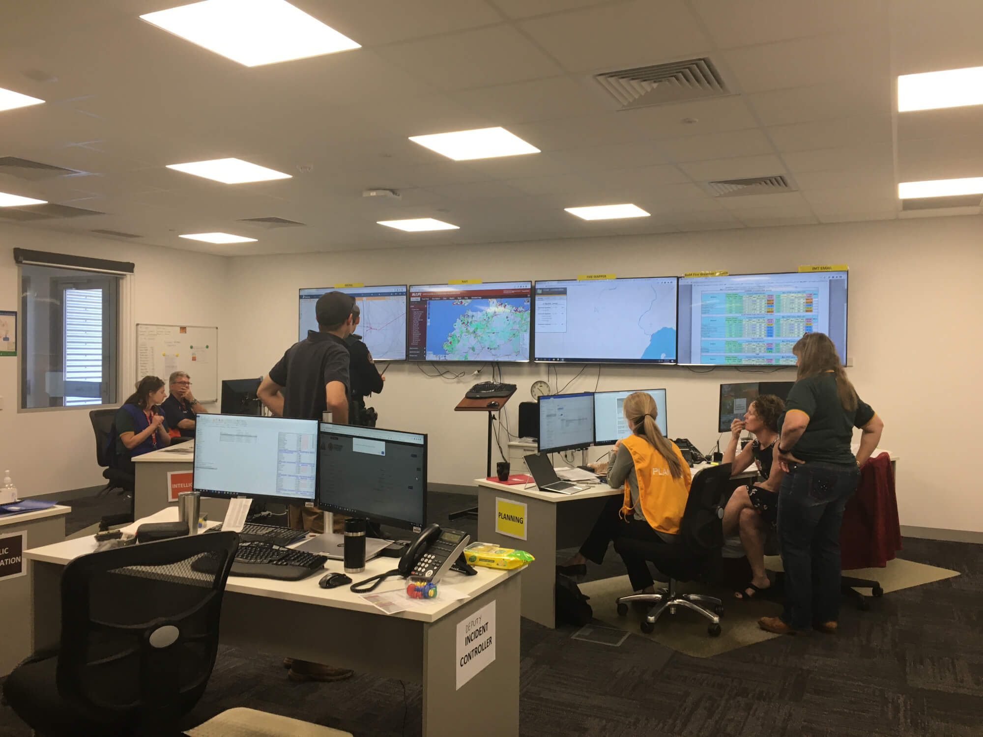 Emergency responders in an office anaylsing data on screens