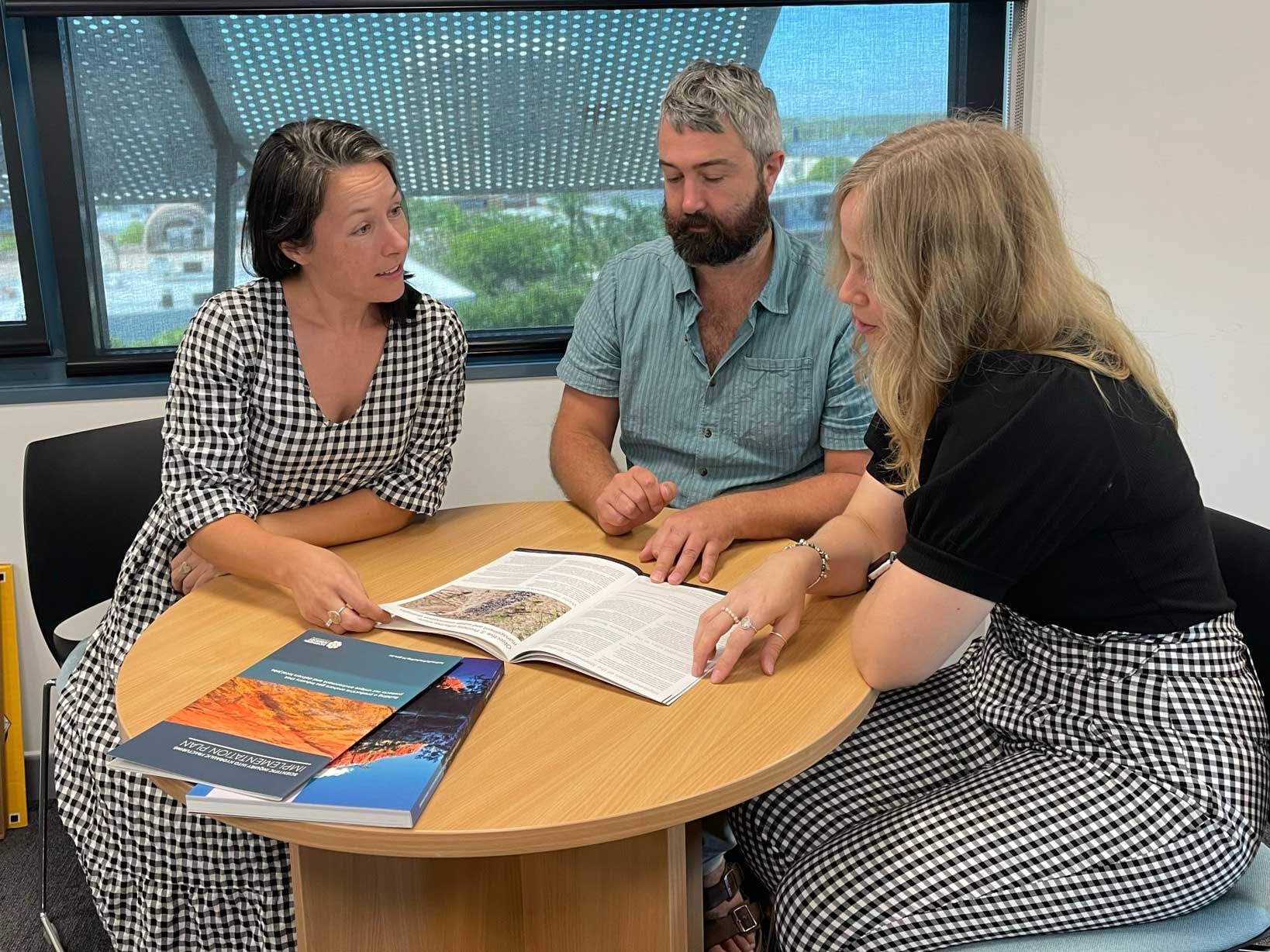 business services staff sitting discussing report